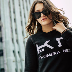 woman wearing a womens black sweatshirt with white komera neza logo
