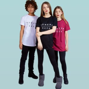 kids wearing white, black, and burgundy t-shirts with komera neza print logo