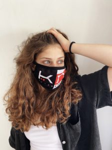 woman wearing a black face mask with KOMERA NEZA logo
